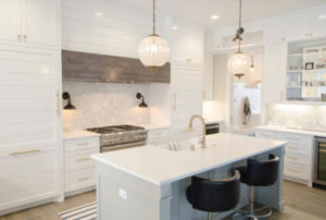 A stunning, all-white kitchen, remodeled with an island and new range.
