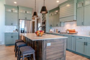 A gorgeously remodeled kitchen, with hardwood floors, custom cabinetry, and a central island.
