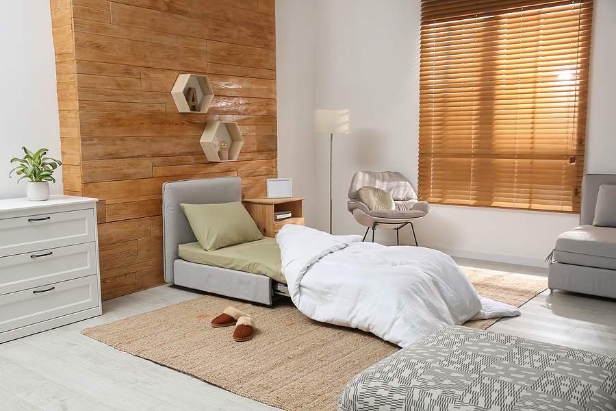 A bedroom with a dramatic wood headboard and matching wood blinds